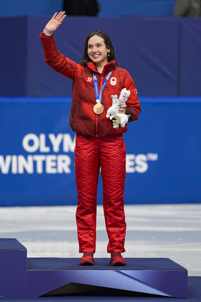 Avec une médaille olympique au cou, Courtney Sarault salue le public, lors des JO d'hiver de Milan-Cortina 2026.