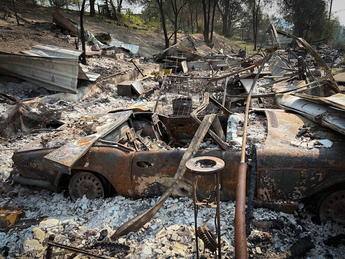 Une maison et une voiture détruite par les flammes à Summerland, le 21 août 2026.