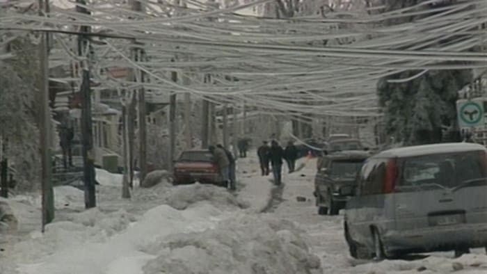 Des fils électriques couverts de glace pendent dangereusement à quelques mètres au-dessus de la rue à Montréal.