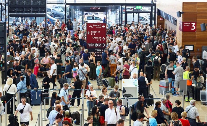 People wait for their flights following the global outage, at BER airport in Berlin, on Friday.