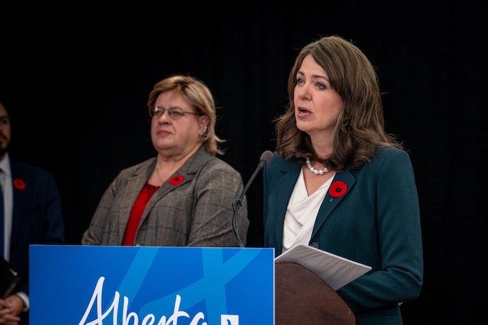 Danielle Smith devant un podium s'adresse aux médias.
