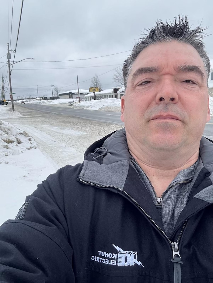 Danny Brisson se prend en photo devant une route.