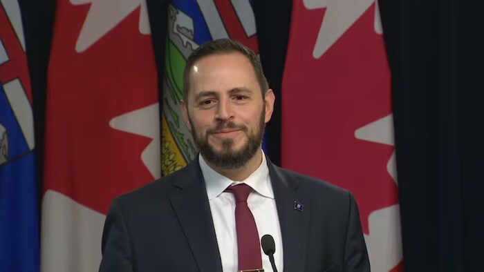 Le ministre albertain de l'Éducation, Demetrios Nicolaides, parle devant un pupitre.