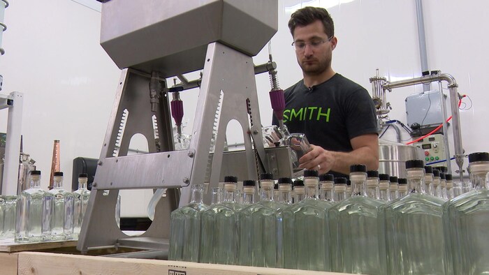 Michael Briand, cofondateur de la distillerie O'Dwyer, remplit des bouteilles de gin.