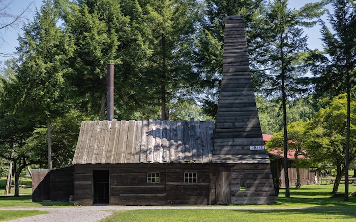 Une cabane de bois avec une grande cheminée.