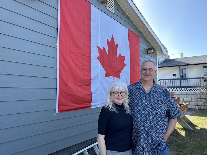 Un mates devant une maison sur lequel il y a un drapeau du Canada.