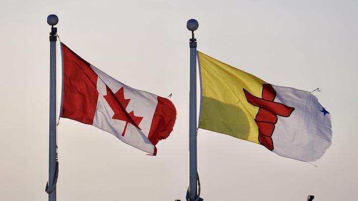 Le drapeau du Canada et le drapeau du Nunavut.
