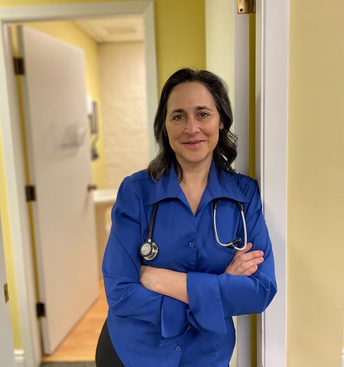 Une médecin porte un stéthoscope autour du cou.