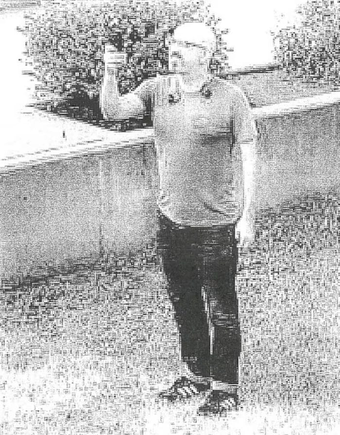 Une image de vidéosurveillance montrant un homme en train de prendre des photographies avec un téléphone cellulaire, à Edmonton, en août 2021.