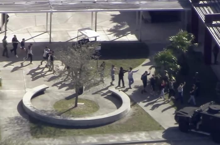 Dans cette capture d'écran fournie par WPLG-TV, des étudiants de l'école secondaire Marjory Stoneman Douglas de Parkland, en Floride, évacuent l'école après une fusillade. 
