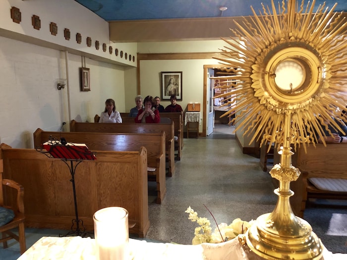 Des gens prient à l'intérieur de la chapelle.