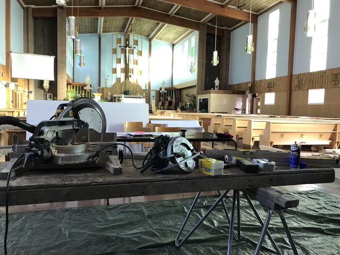 Des outils sont placés sur une table de travail dans une église.