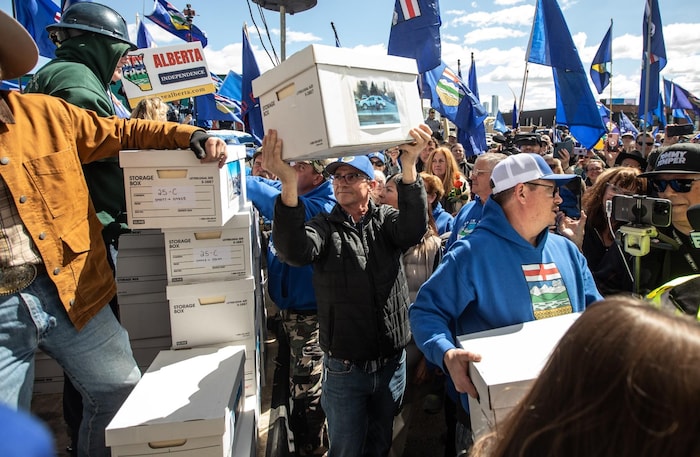 Des personnes transportent des boîtes lors d'un rassemblement.