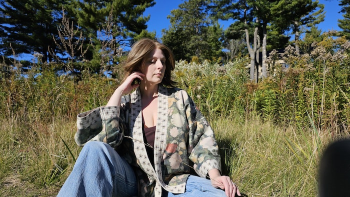 Une femme se prélasse au milieu de la nature.