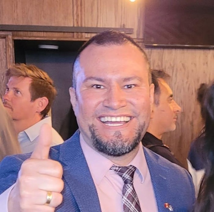 Un homme souriant avec le pouce levé. 