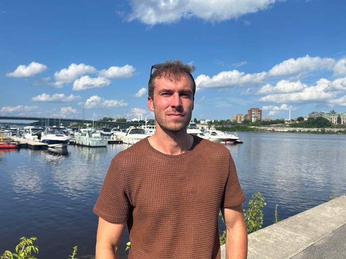 Etienne Cameron poses in front of a marina.