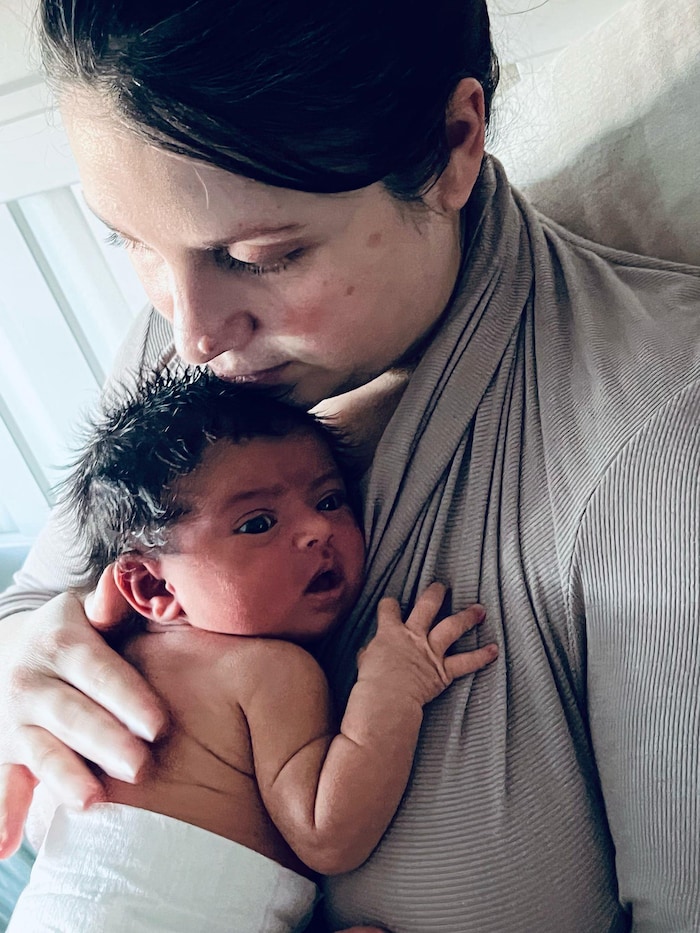 Ève Péclet tient lad enfant dans ses bras.
