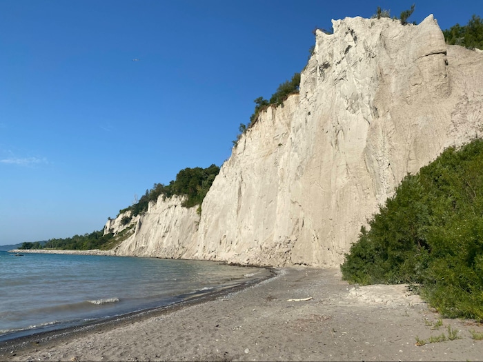 Un coin de plage avec une falaise et le lac Ontario.