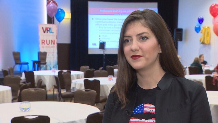 Erin Vilardi porte un veston noir sur un t-shirt aux couleurs du drapeau des États-Unis.