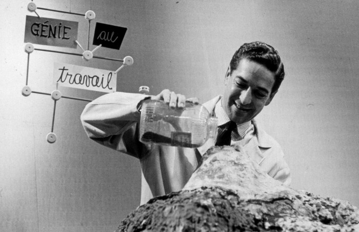 L'animateur Fernand Seguin verse du sable sur une table pour former un volcan.