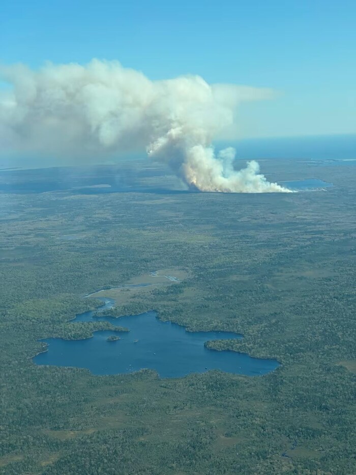 Sur une photo aérienne, on voit deux lacs et une épaisse fumée et des flammes qui montent.