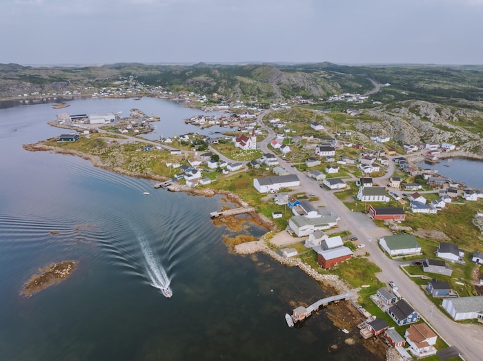 Photo aérienne d'une île avec des quais et un bateau qui passe du nord au sud.