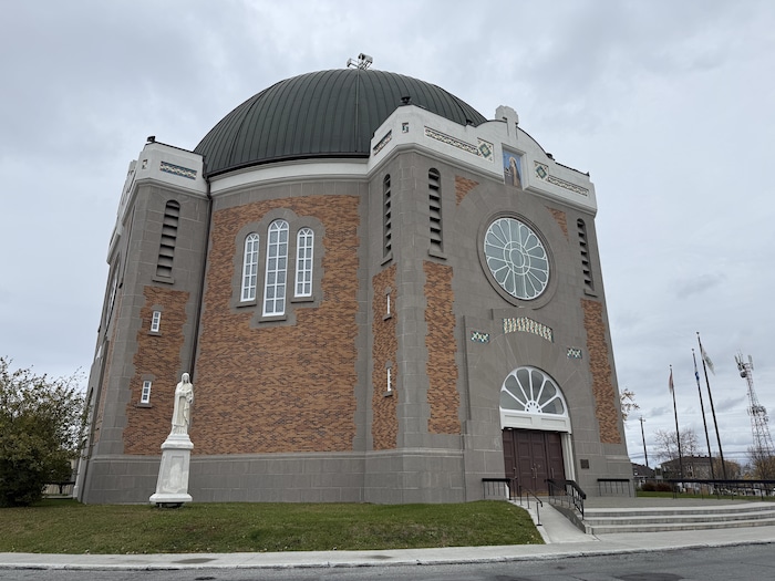 Photo de la façade de la cathédrale d'Amos, une haute bâtisse en briques.
