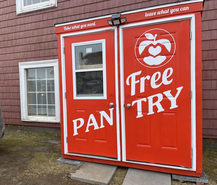 Deux portes peintes en rouge vif avec les mots « Free Pantry » peints en grosses lettres blanches.