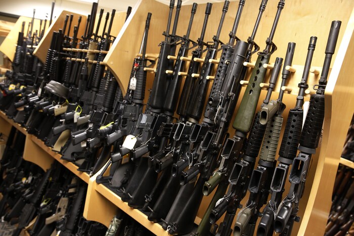 Des carabines AR-15 sont alignées sur une étagère.