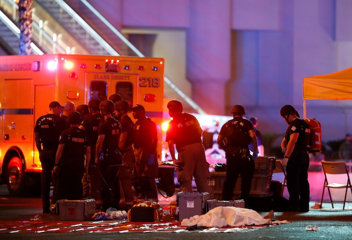 Des policiers et des pompiers rassemblés près du corps d'une victime.