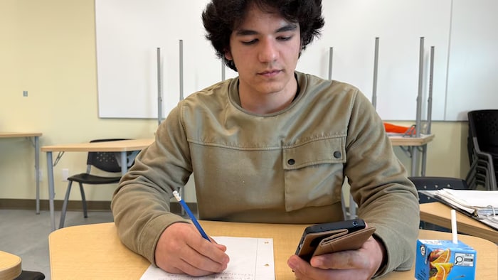 Gabriel Morris a le regard rivé sur son téléphone intelligent.