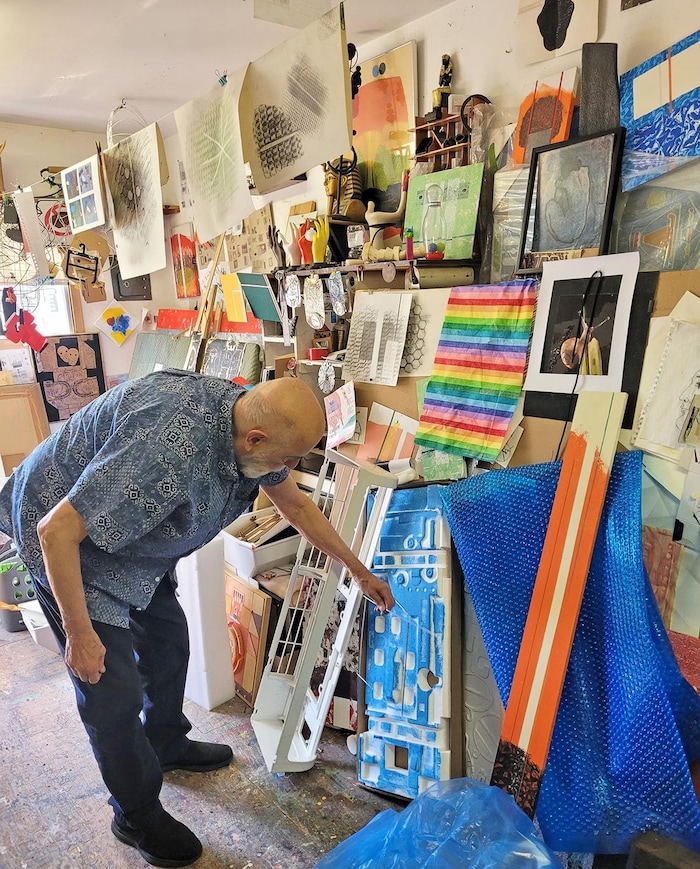Georges Goguen regarde une toile dans son atelier.