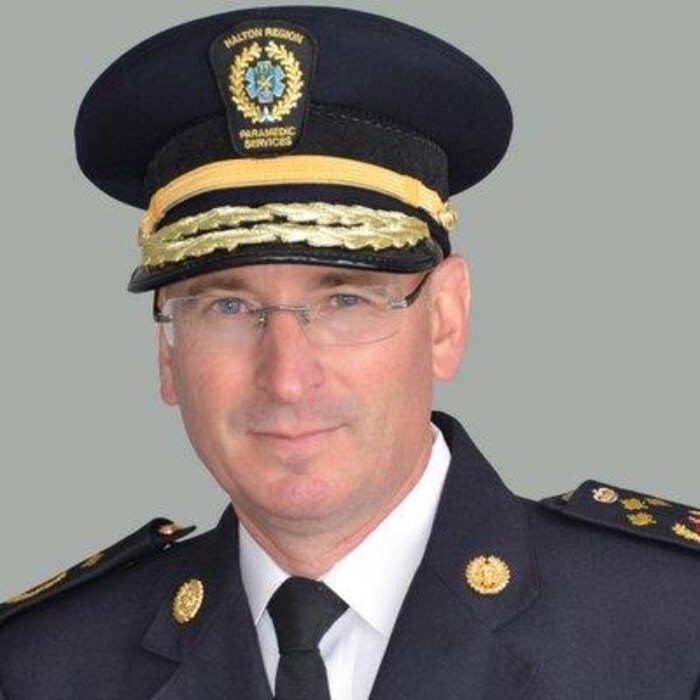 Greg Sage dans sa tenue de responsable du work ambulancier qui regarde la caméra.