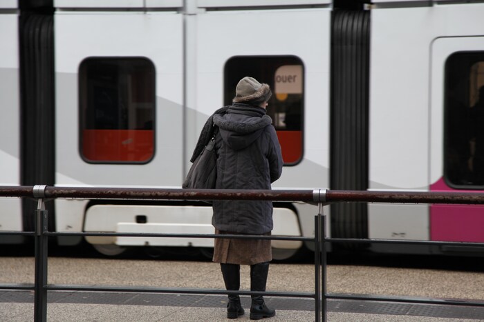 Une résidente de Grenoble attend le tramway.