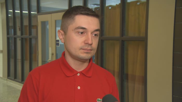 Un homme en entrevue avec Radio-Canada dans un couloir.