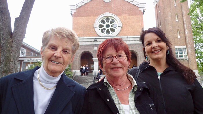 De gauche à droite : Normay St-Pierre du Mouvement Retrouvailles, Susan Pariseau administratrice de la page Facebook L'Histoire des Crèches au Québec, et Lyne Perron administratrice de la page Facebook Adoption, émotions, retrouvailles. Les trois femmes posent devant l'église Sainte-Claire.