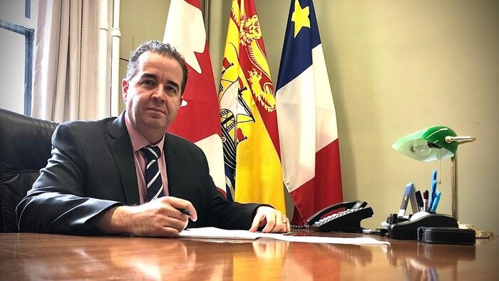 Jean-Claude D'Amours assis à son bureau.