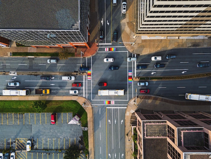 Une intersection photographiée de haut par un drone. On voit de nombreuses automobiles et des autobus.