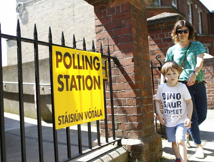 Une femme quitte un bureau de vote sur le référendum au sujet de l'avortement en Irlande.