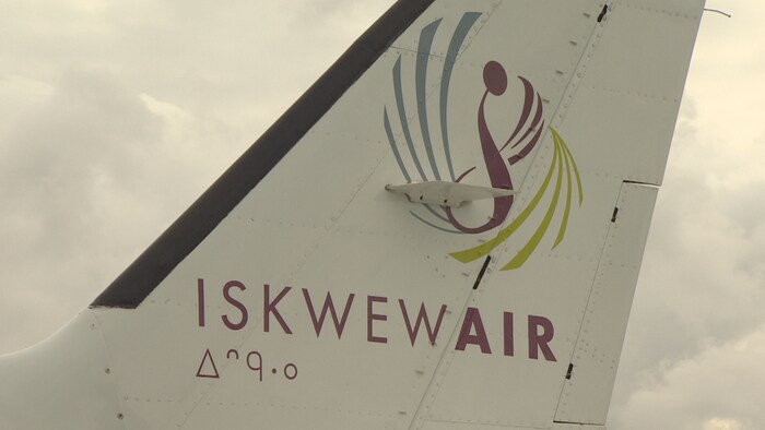 Plan serré d'un logo sous lequel il est écrit Iskwew Air sur l'aileron arrière d'un avion.