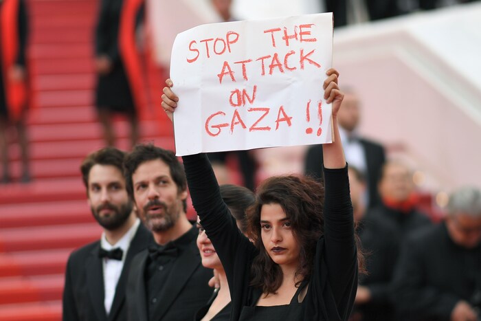 L'actrice Manal Issa, vêtue de noir, brandit une affiche.