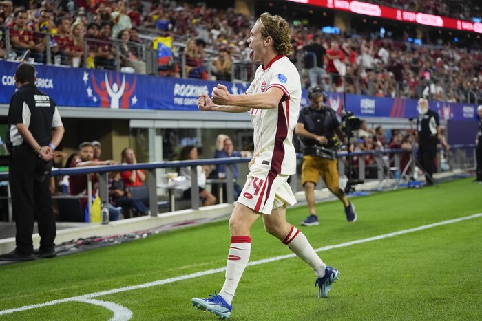 Jacob Shaffelburg de profil, sur un terrain de soccer, tire la langue et serre les deux poings en faisant face aux spectateurs après avoir compté un but.