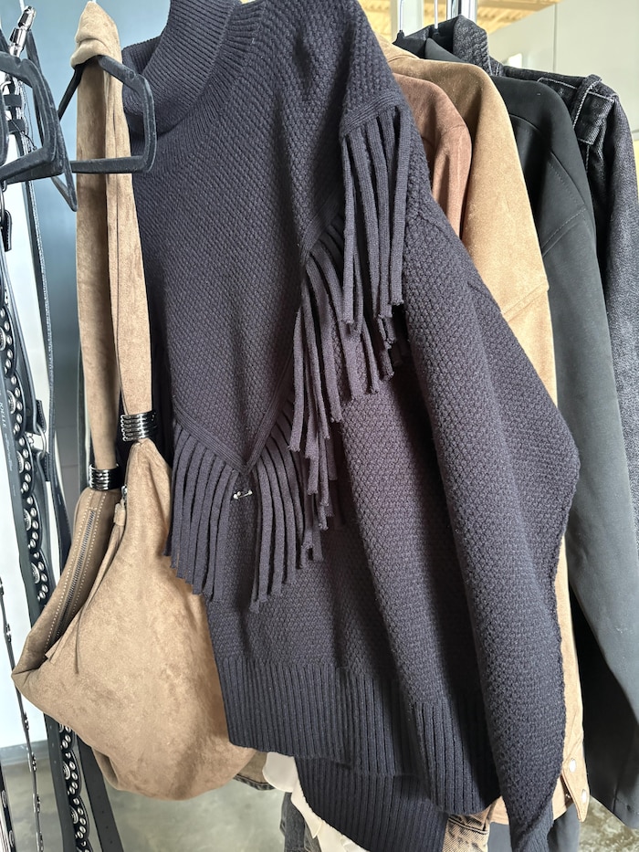 Chandail en lainage avec des franges et un sac en suède.