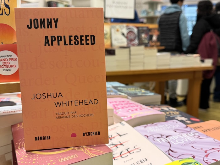 Un livre posé sur une pile de livres dans une librairie.