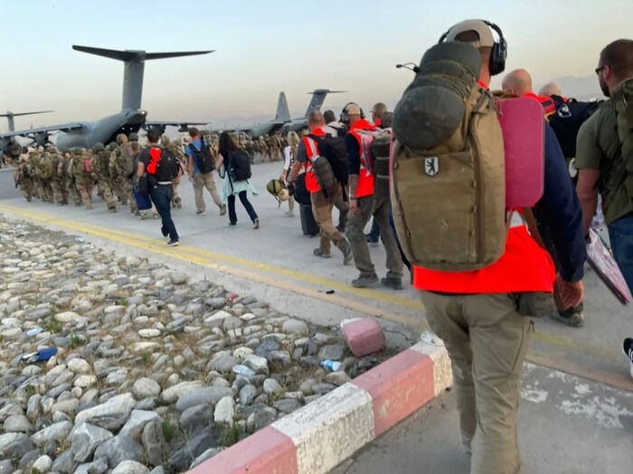 Military and evacuees with emergency vests queuing to board the last German plane out of Kabul Airport on August 26, 2021.