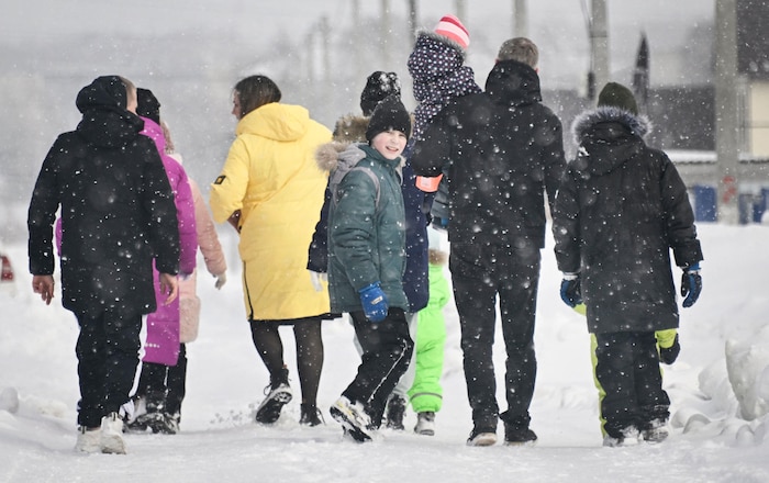 Une famille nombreuse marchant dans la neige.