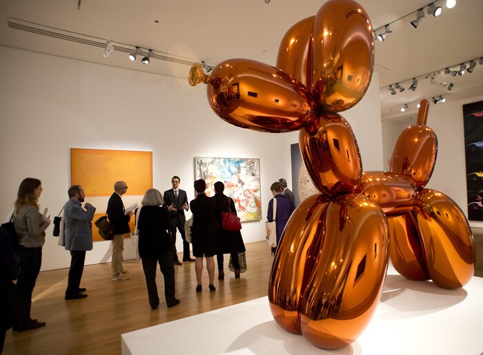 Une sculpture géante d'un chien en ballons oranges est présentée dans un musée.