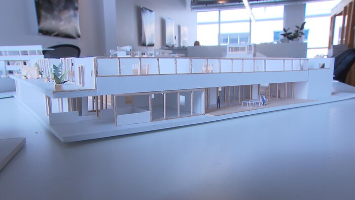 Une maquette d'école posée sur une table dans une salle dotée de fenêtres.