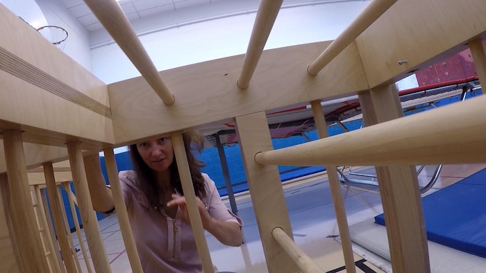 Un labyrinthe fait de barreaux de bois et l'éducatrice