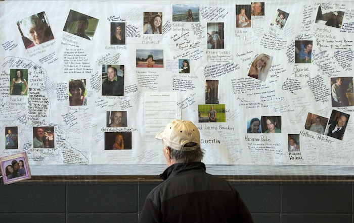 Un homme regarde des photos des victimes de la tragédie de Lac-Mégantic.